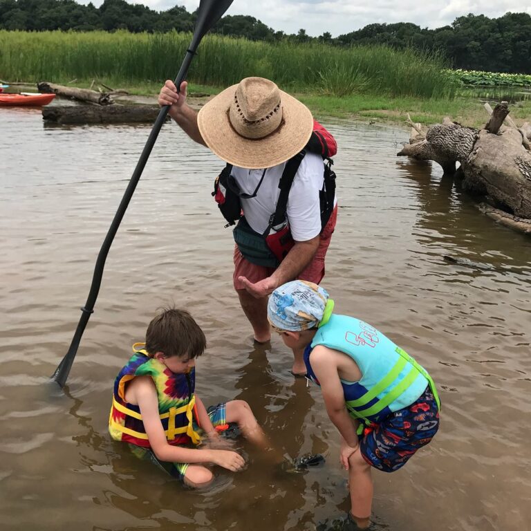 kids exploring river ecology by kayak